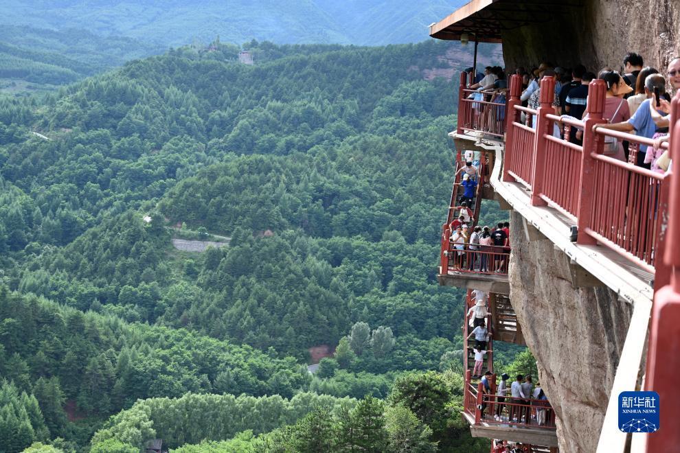 7月30日,游客在麦积山石窟参观游览.