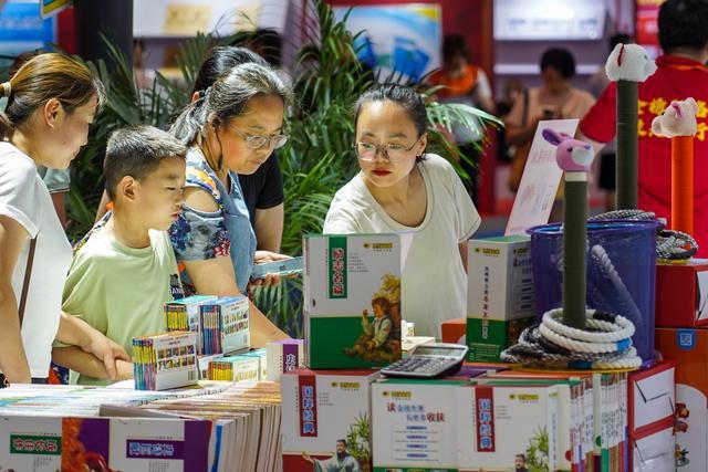 7月31日，在第31届全国图书交易博览会上，读者在阅览选购新书。新华社记者 朱峥 摄