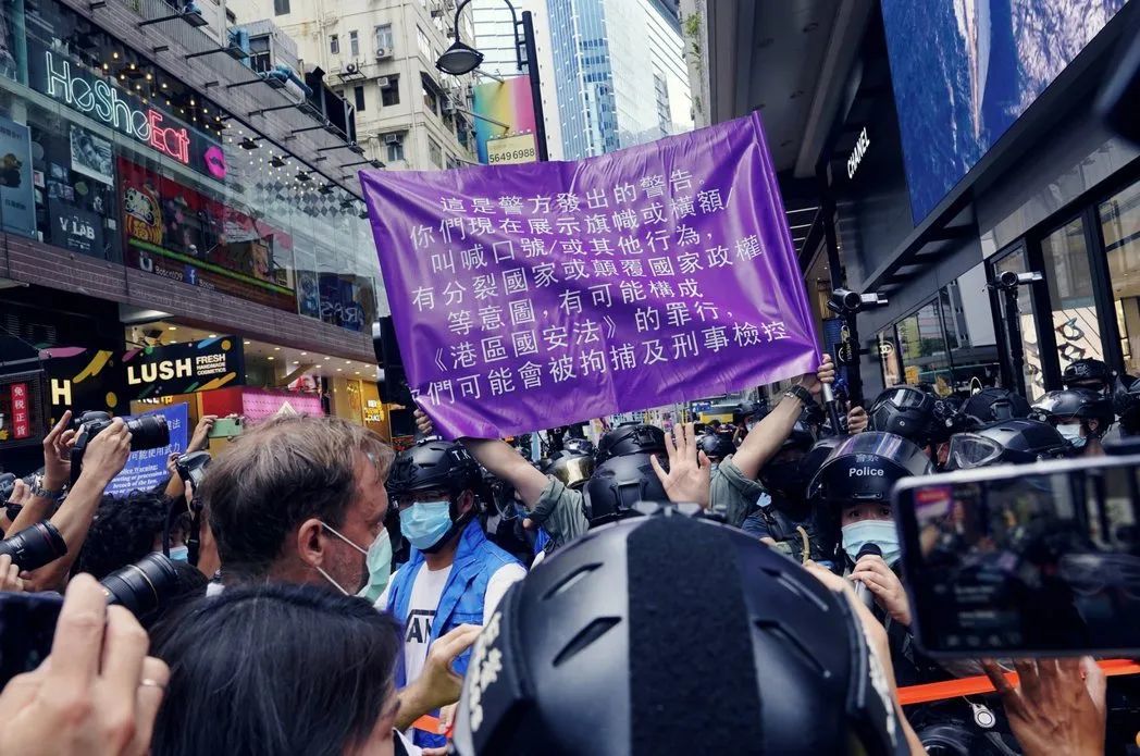 ▎2020年7月1日，港警首度举起港版国安法的紫旗警告。图源：美联社