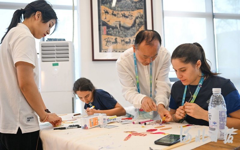 8月1日，成都皮影艺术博物馆馆长赵洪（右二）在指导意大利运动员绘制皮影。