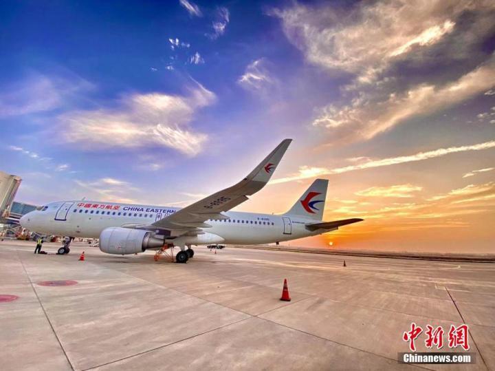 金黄色的旭日从地平线缓缓升起，飞机机身上也被绚丽的朝霞涂上了“日出”色彩。