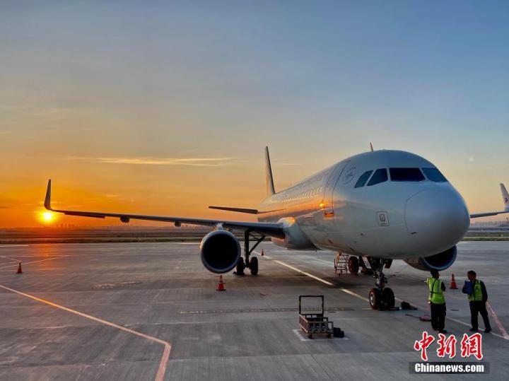 停机坪上，旭日缓缓升起，机务人员开始了一天的检查工作。