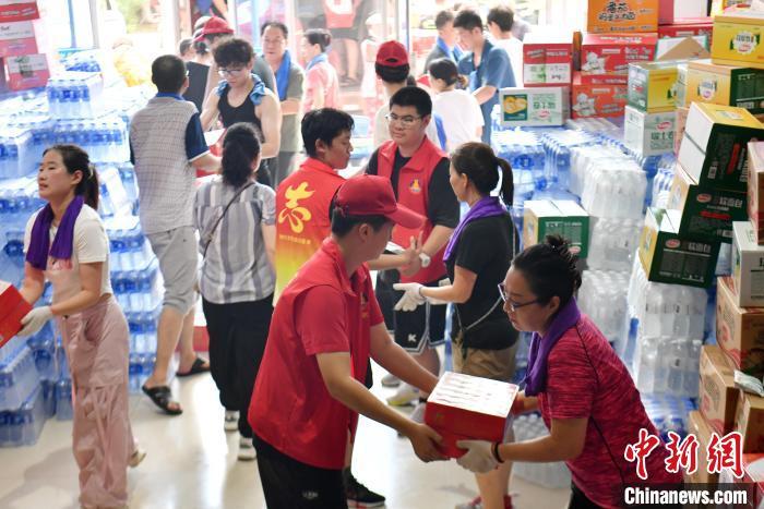8月4日，在涿州市职业技术教育中心，志愿者正在搬运救灾物资。　中新社记者 韩冰 摄
