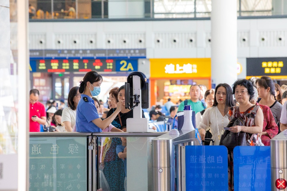 赣州西站工作人员正在帮助旅客验证进站乘车。邹阳 摄