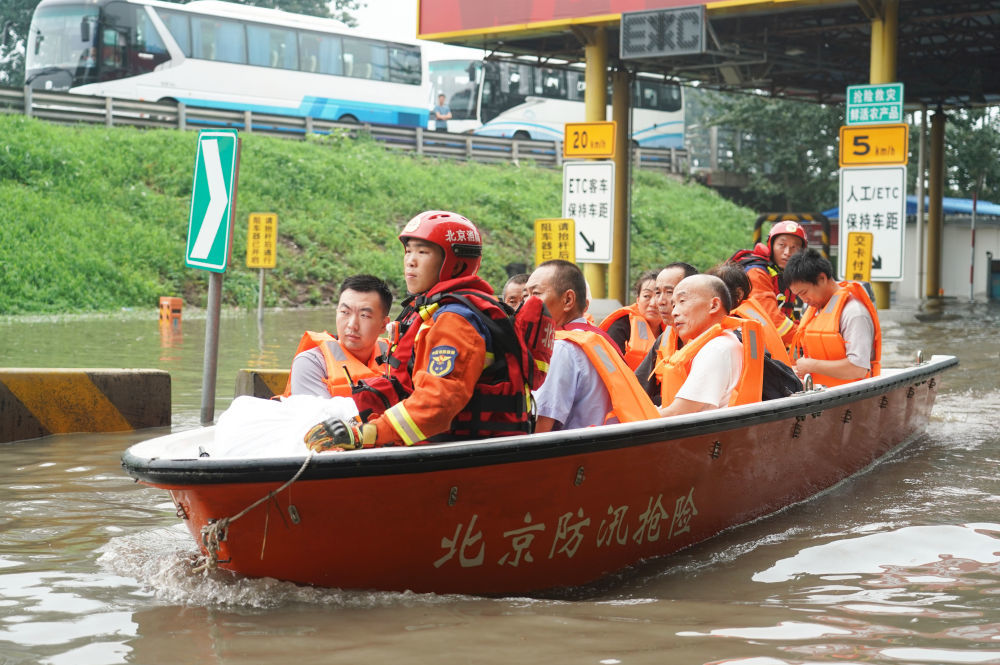 8月2日，在北京市房山区的京港澳高速琉璃河出口，受灾群众乘坐冲锋舟前往转运车辆乘车点。新华社记者 任超 摄