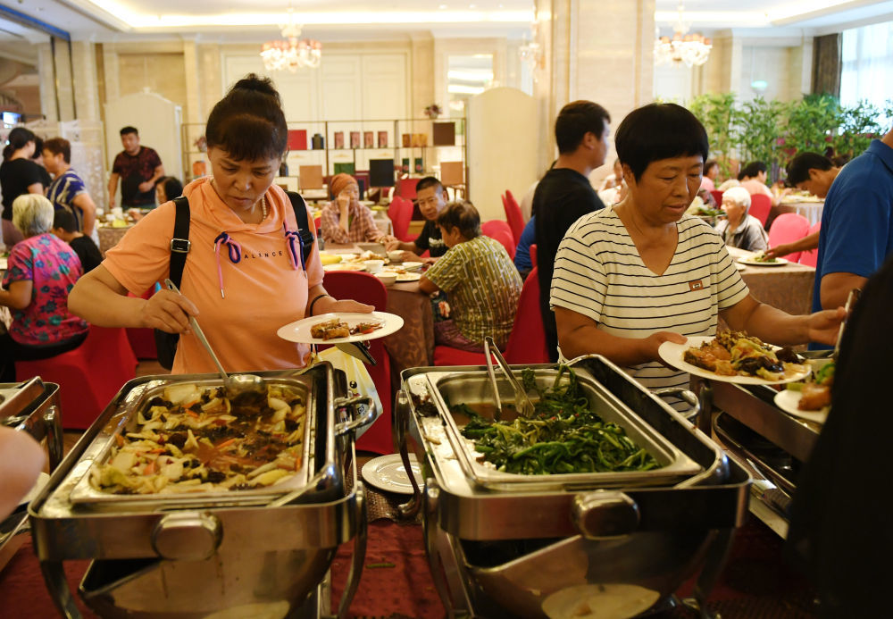 8月1日，北京市房山区青龙湖镇的村民在临时安置点用餐。新华社记者 张晨霖 摄