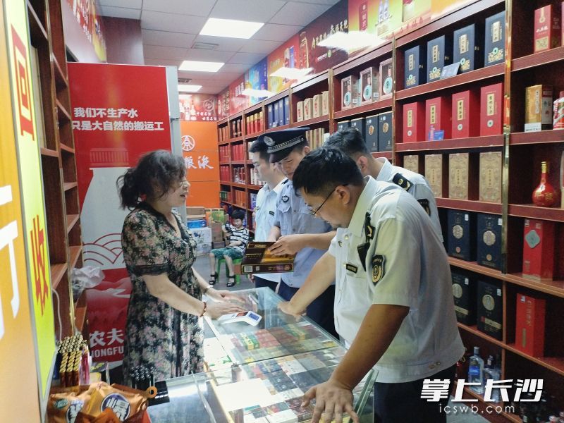 民警及烟草专卖局工作人员对售卖卷烟的门店进行突击检查。