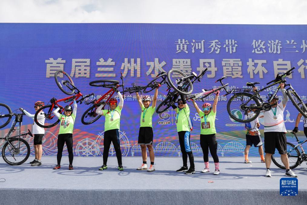 8月5日，完成全线路骑行后，骑行爱好者在兰州奥体中心活动现场合影。新华社记者 方欣 摄