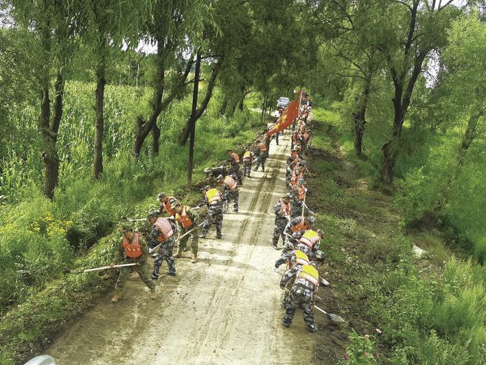 民兵迅速集结，帮助群众清理道路淤泥。 张鑫多 摄