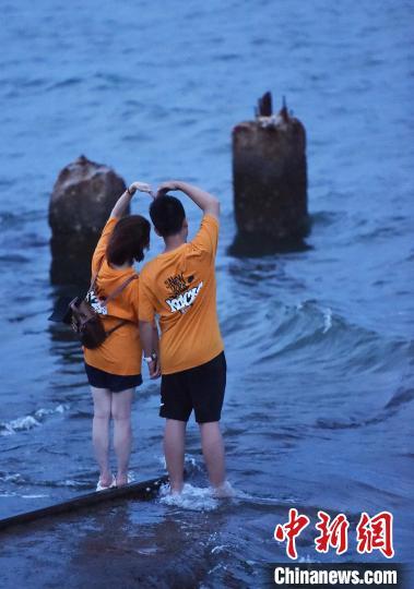 图为游客在铁轨上“比心”。曲正扬 摄