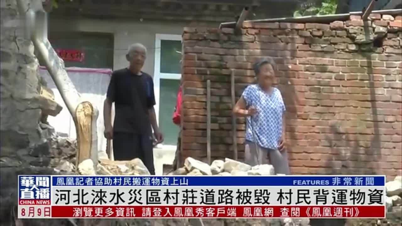 河北涞水灾区村庄道路被毁 村民背运物资