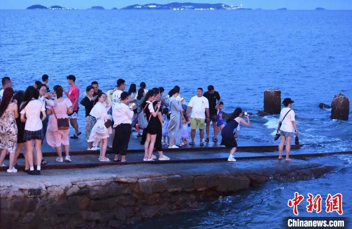 暮色降临，仍有不少游客在排队拍照。曲正扬 摄