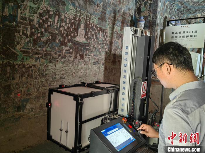 工作人员在莫高窟第341窟对壁画进行数字化采集 应妮摄