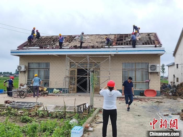 工人在维修受损房屋。谷华 摄