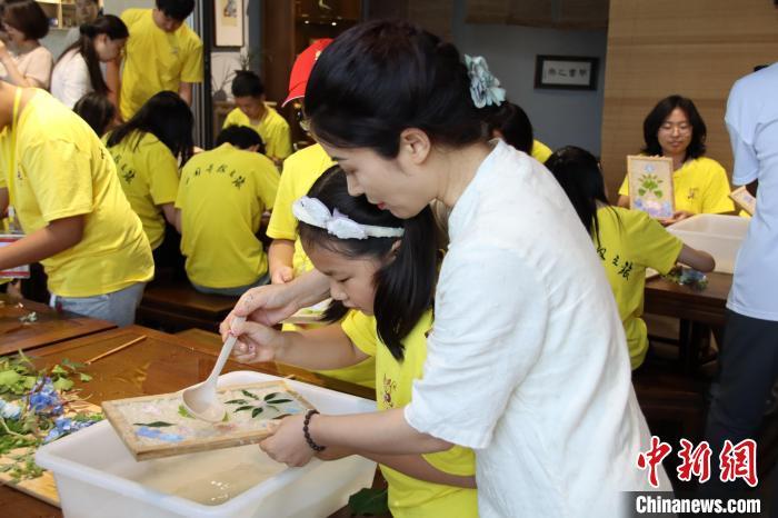 图为老师手把手指导小营员进行二次淋浆。梁国宏 摄