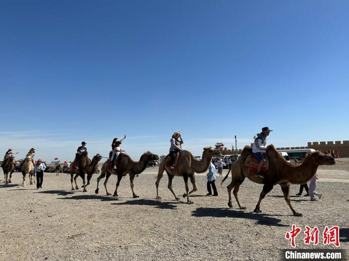 图为游客在嘉峪关关城骑骆驼游览景区，聆听丝路驼声。戴文昌 摄