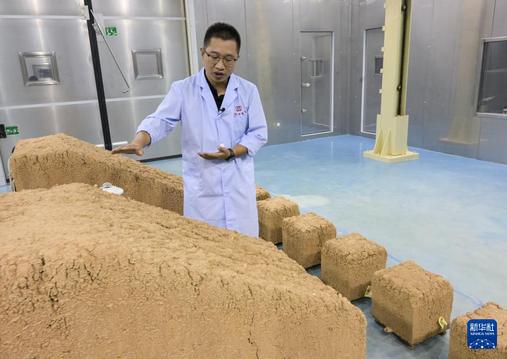 在敦煌研究院多场耦合实验室内，一位工作人员介绍针对陕西西安秦东陵模型所进行的环境模拟实验情况（8月3日摄）。新华社记者 李贺 摄