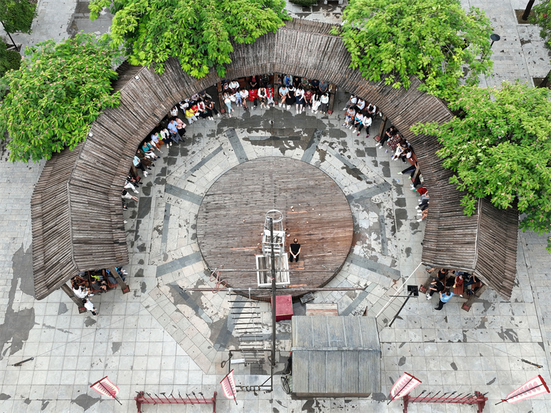 8月12日，在河北省沧州市吴桥杂技大世界景区江湖文化城，游客们观看杂技艺人表演传统杂技节目（无人机照片）。
