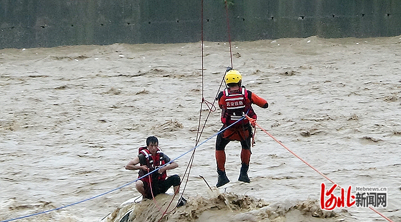 7月30日，在赵亚朋（右）的安抚和指导下，被困人员正穿戴救生衣。（资料图片）河北日报通讯员田晓川供图