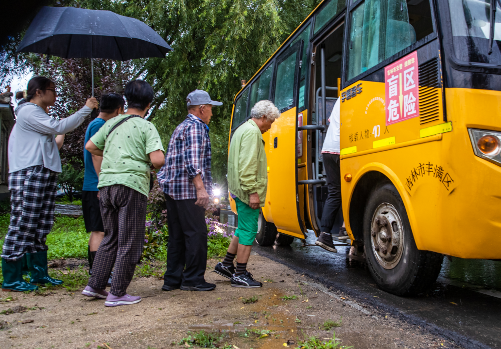 8月12日，前二道乡金丰家园小区居民正在有序排队转移。张景峰 摄