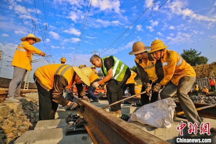 圖為鐵路工人對(duì)新鋪的軌道平順度進(jìn)行調(diào)整定位。張中海 攝