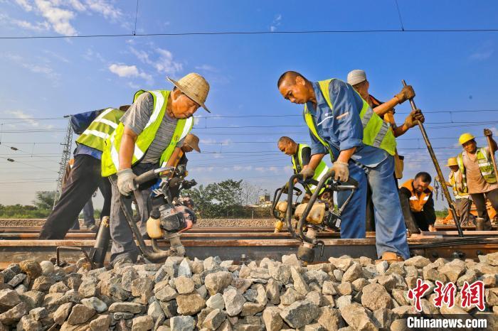 圖為鐵路工人對(duì)更新的道岔進(jìn)行手工搗固整修。張中海 攝