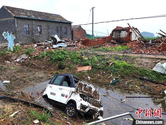 电动三轮车被大风刮入河中。谷华 摄