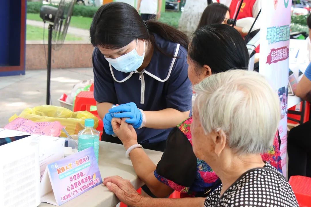 心血管检测摊位的志愿者正在为市民抽血检查