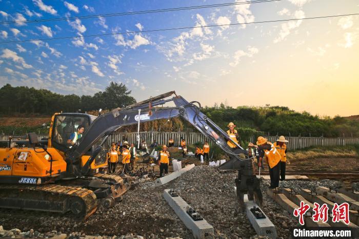 圖為大型機(jī)械車(chē)將新混凝土軌枕推送到位。張中海 攝