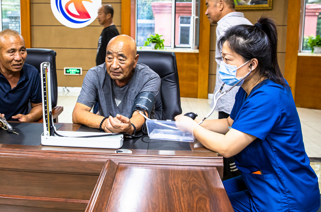 8月12日，医护人员在吉林市城际养老中心防汛安置点为村民检查身体。 张景峰 摄
