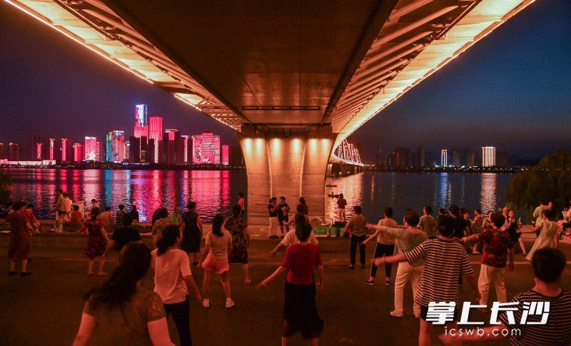 夏夜，市民们在桥下舞动。