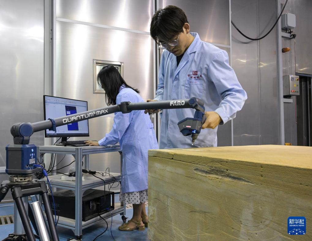 在敦煌研究院多场耦合实验室中，工作人员对庆阳北石窟寺砂岩样品进行三维扫描分析（8月3日摄）。新华社记者 李贺 摄