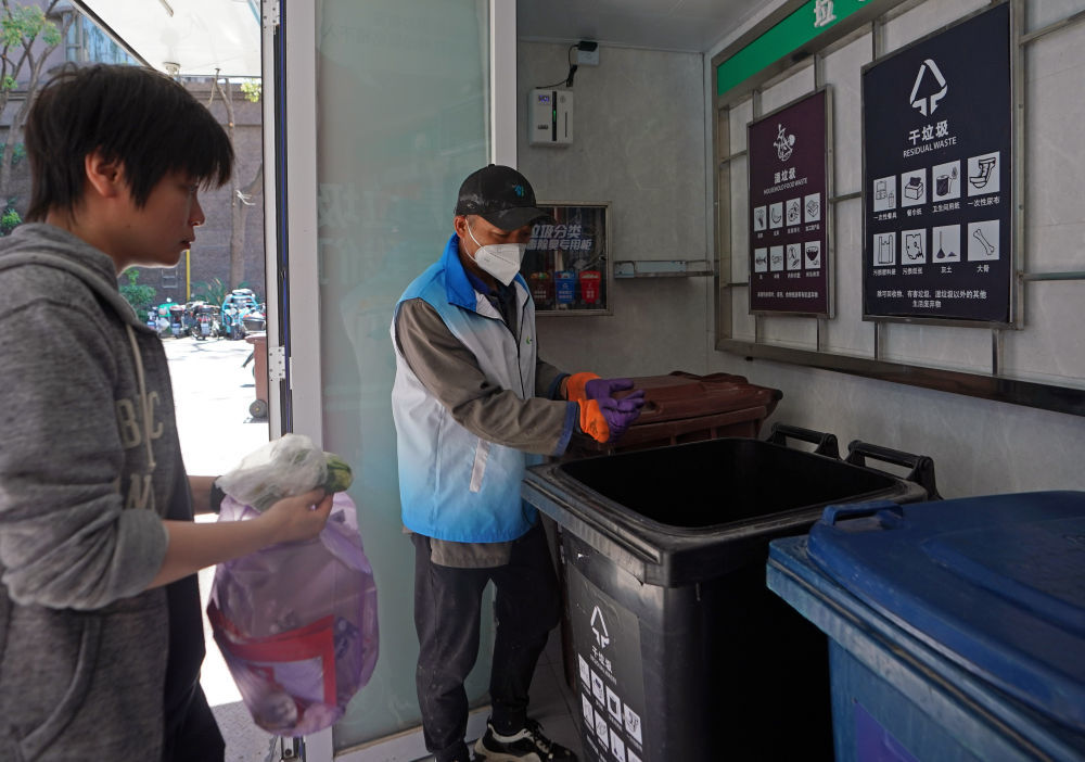 在上海市虹口区嘉兴路街道爱家豪庭小区，垃圾分类志愿者在投放时间段内服务（2023年5月23日摄）。新华社记者 刘颖 摄