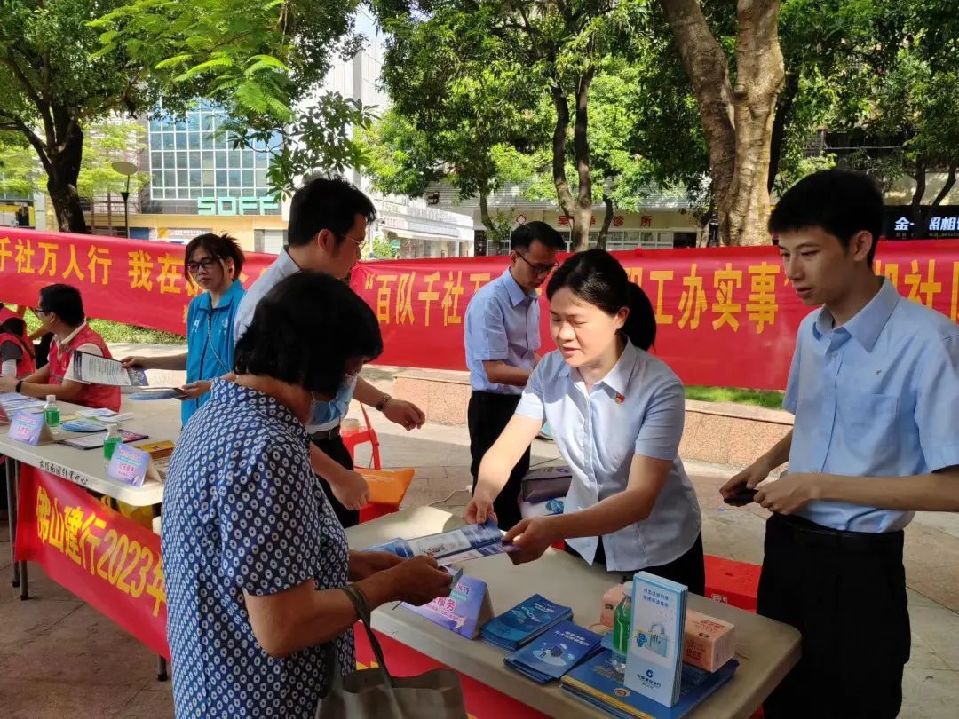 金融服务摊位的志愿者向市民派发宣传册。
