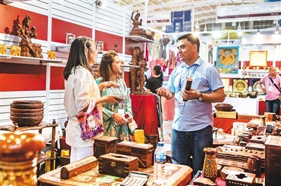 图为第七届中国—南亚博览会尼泊尔展区的参展商（右）在推介特色商品。新华社记者 胡 超摄