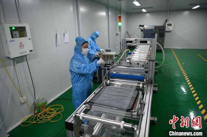 8月17日，涿州市柯林电子产品有限公司的工作人员正在调试生产机器。中新社记者 翟羽佳 摄