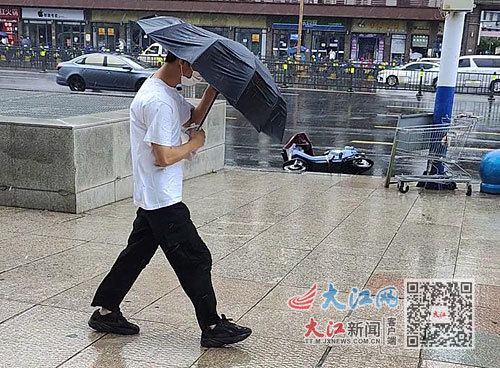 8月28日，南昌街头行人顶着风雨前行。