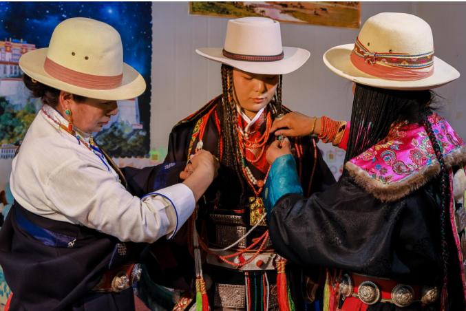 娶亲日的清晨,新娘的母亲和长辈为新娘穿衣服、佩戴“依玛阿锐”及各种首饰。