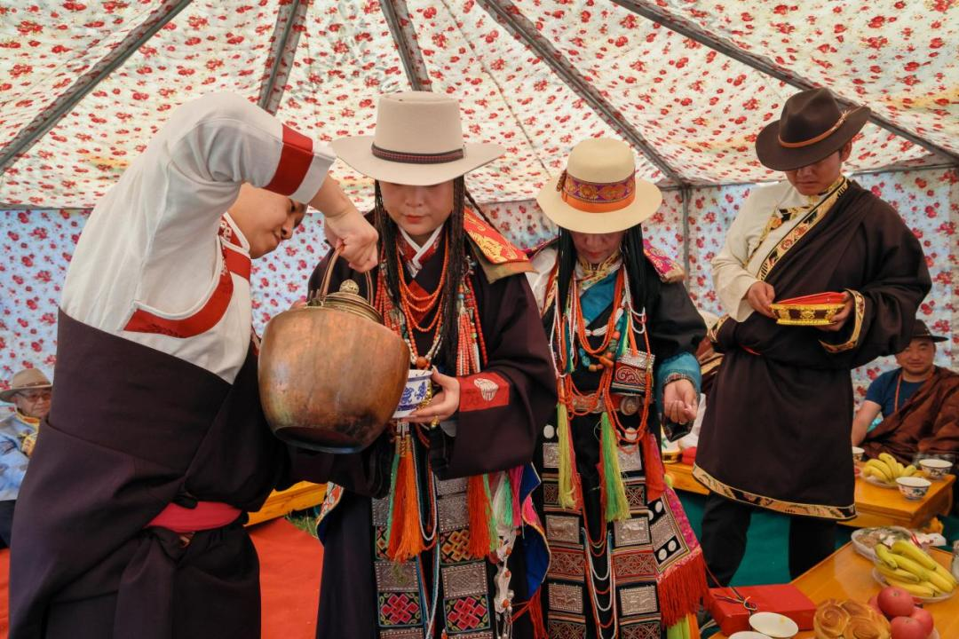 新郎倒“瓦加”茶(意为新娘熬制的茶),新娘在伴娘陪伴下给男方家长辈敬茶。