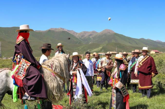 男方女东手持哈达迎接新娘下马