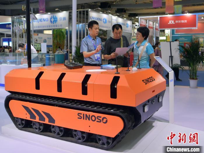 8月25日，在中国—东北亚博览会现代农业馆，李伟巍(左一)向客户介绍一款果园机器人。刘栋 摄