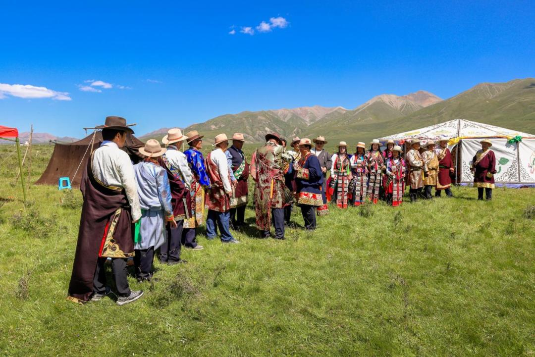 喜客被东家拦在主帐篷门前敬拦门盅酒,女东则高唱迎客酒曲。