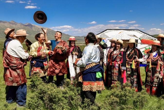 为男方东家和喜客互抢帽子戏闹逗乐