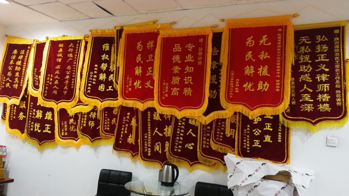 公益中心办公室的墙上层层叠叠挂满受援群众送来的锦旗