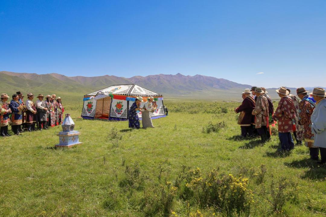 图为两名少女用柏枝醮碗中清水为新娘引路,碗中由喜客方长辈象征性放入钱币,意为开财路。