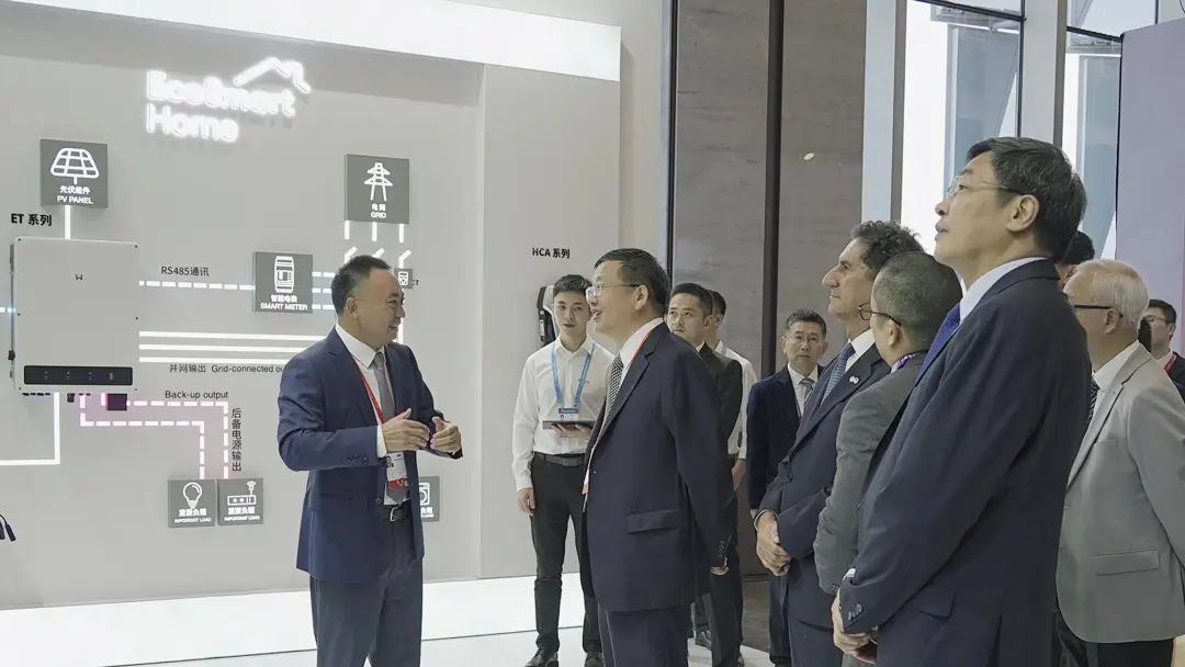 在展台前，固德威董事长黄敏向来宾介绍 图片来源：固德威