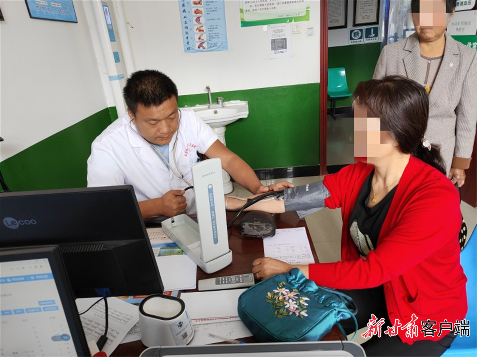 李明明为患者测量血压