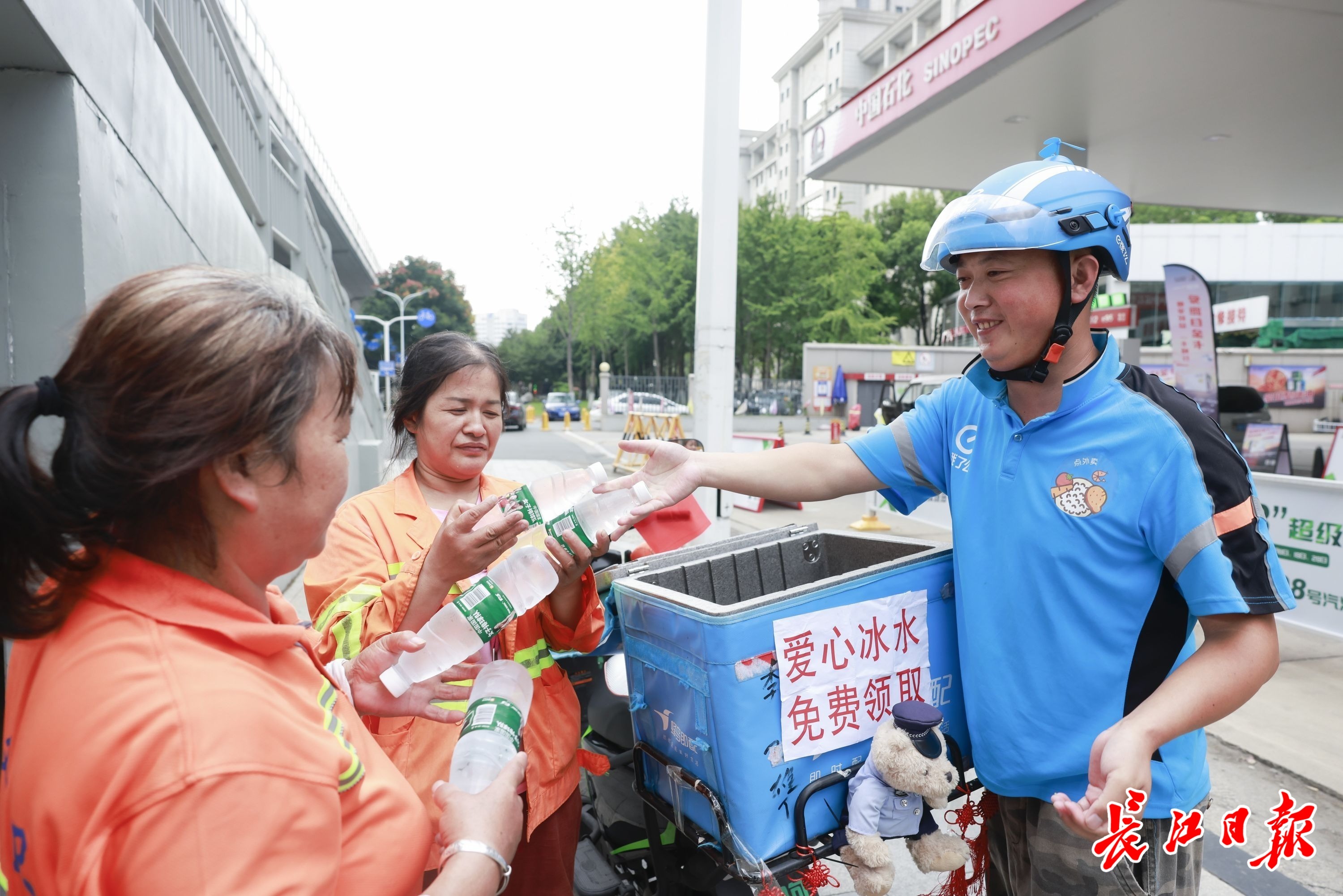 张宝剑在街头为环卫工送水。长江日报记者胡冬冬 摄