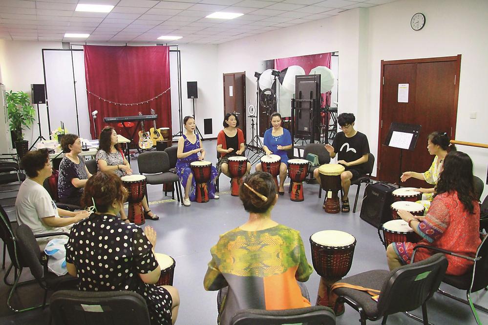 非洲鼓教室里，学员们正在学习敲击的节奏和韵律。