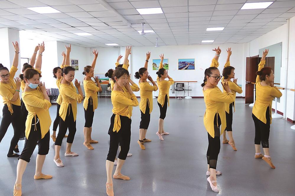 身着统一服装的民族舞学员们正在老师的指导下舞动身姿。